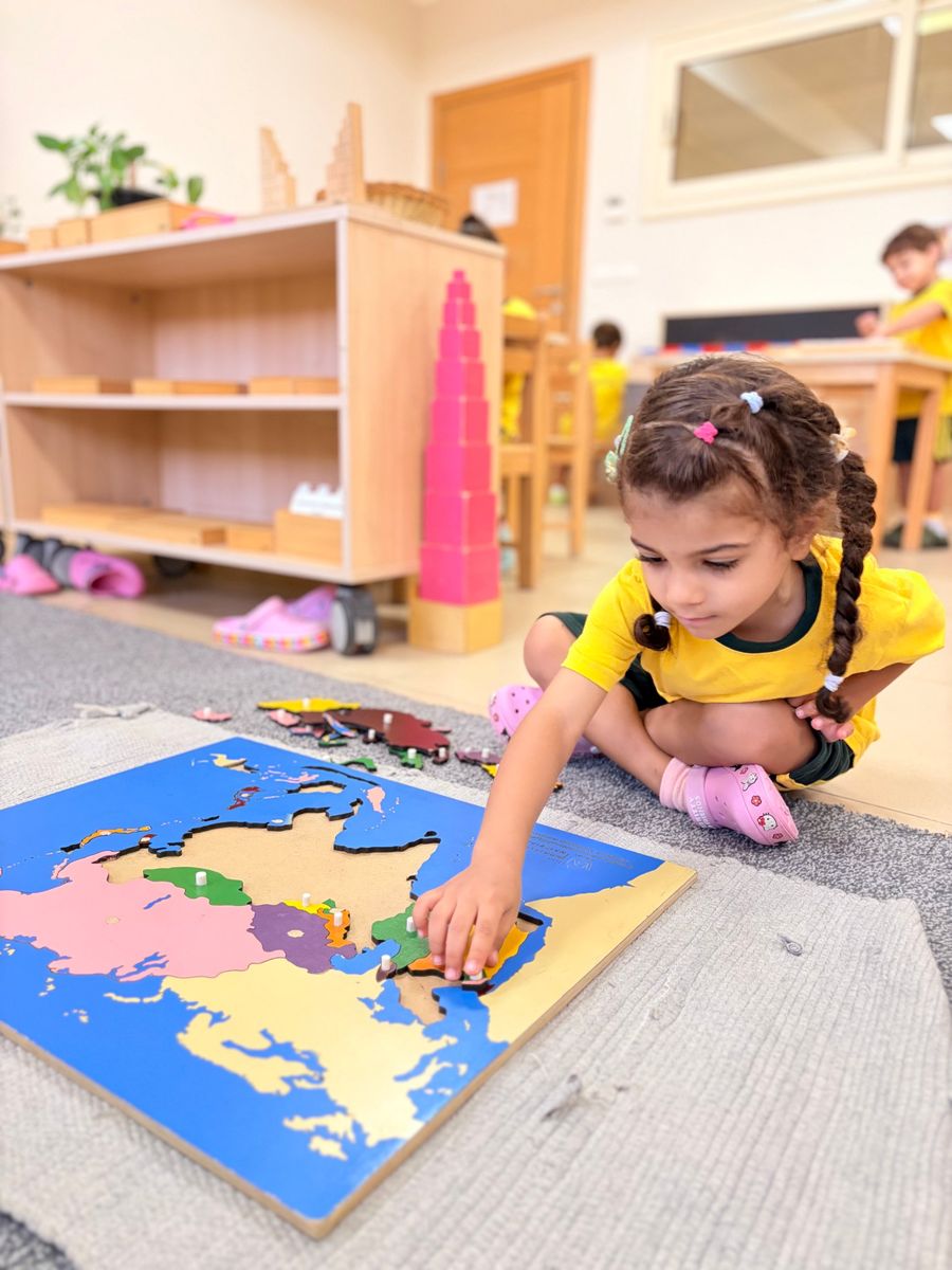 An Early Years child completing a Montessori map puzzle