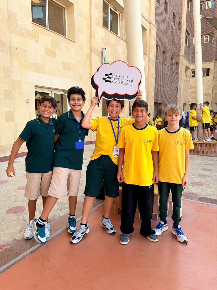 EVO students on campus holding an Evolution International School sign